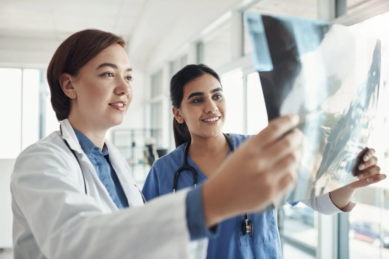 People, doctor and nurse with smile, xray and radiology in hospital for consultation, results and treatment. Medical, team and collaboration in review of scan in healthcare, specialist and diagnosis People, doctor and nurse with smile, xray and radiology in hospital for consultation, results and treatment. Medical, team and collaboration in review of scan in healthcare, specialist and diagnosis